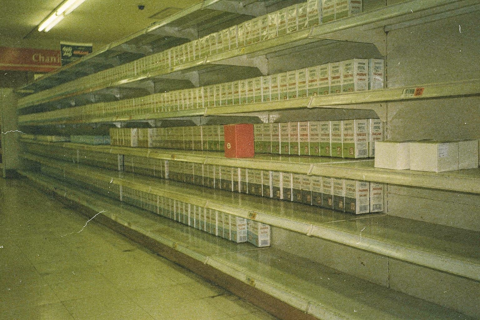 A red product with one facing among competitors occupying most of a supermarket shelf